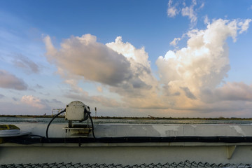 Light for helideck on board a construction work barge at oil field during sunset