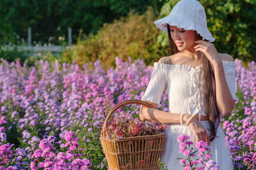 Obraz premium young woman in white dress with flowers garden