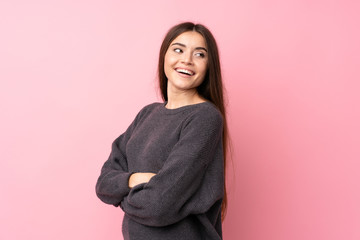 Fototapeta premium Young woman over isolated pink background with arms crossed and happy