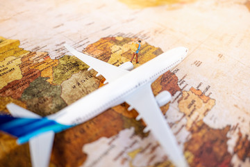 Fototapeta na wymiar Miniature people: Backpacker on vintage world map with airplane using as business trip traveler adviser agency or explorer on earth background concept. 