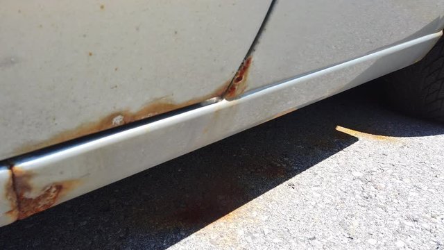 Flat Tire And Rust Along Bottom Of Car Closeup Right To Left Pan