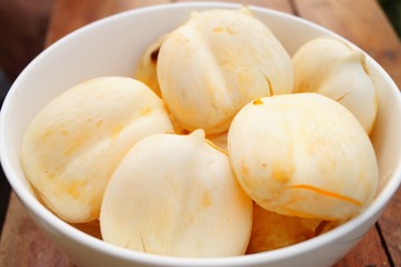 Palmyra palm are in a white glass bowl laying on a threshing basket. It’s clean and healthy fruits from nature. 