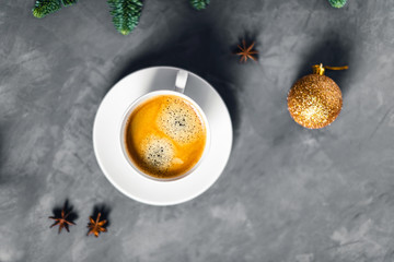 Obraz na płótnie Canvas Christmas picture with white cup of tasty coffee and one golden ball.