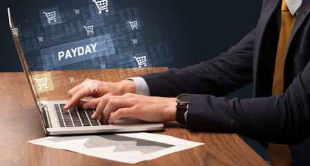 Obraz na płótnie Canvas Businessman working on laptop with PAYDAY inscription, online shopping concept