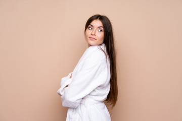 Obraz premium Young girl in a bathrobe over isolated background laughing