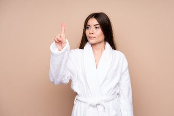 Young girl in a bathrobe over isolated background touching on transparent screen