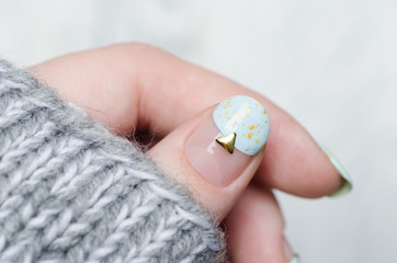 gentle mint blue manicure with gold glitter, stripes pattern and metal rivets