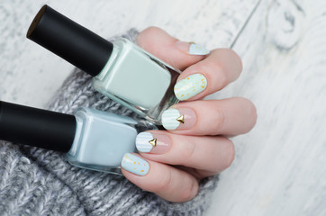 gentle mint blue manicure with gold glitter, stripes pattern and metal rivets