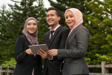 Young Asian Malay Executive at the park wearing suit