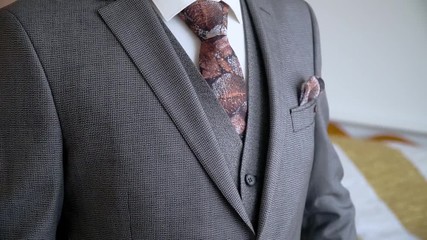 Businessman in a suit fastening buttons on his jacket. Man hands buttoning jacket close up