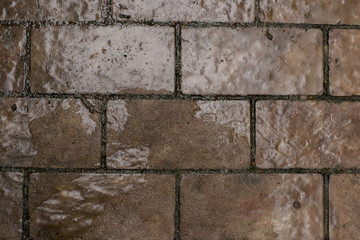 Street gray-brown tile covered with ice. Street.