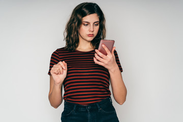 Young beautiful woman browsing smartphone posing in studio