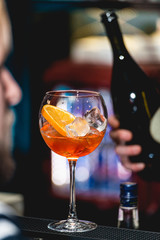 glass of refreshing orange alcoholic cocktail on a table in the bar