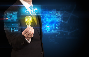 Businessman holding lightbulb with INTERNAL CONTROL inscription, online security idea concept