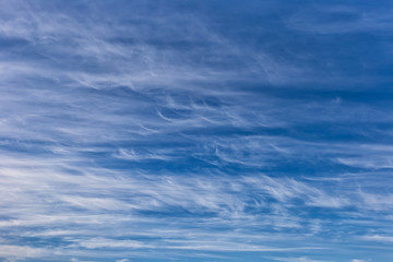 Beautiful cirrus clouds on a blue autumn sky in a frosty day. Sky pattern.