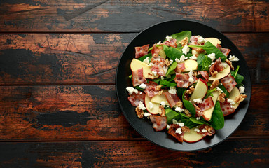 Bacon, Apple Salad with spinach, walnuts and feta cheese. on wooden table. healthy food.