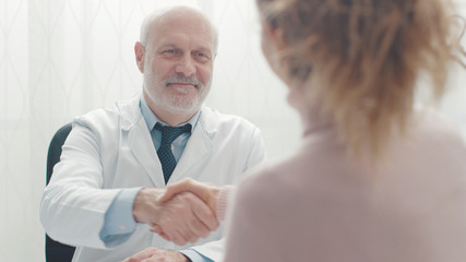 Fototapeta premium Doctor and patient shaking hands in the office