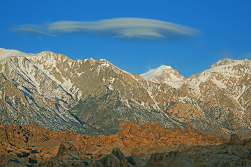 Fototapeta na wymiar Lenticular cloud floats above the Eastern Sierra Nevada Mountains and Alabama Hills, Lone Pine, California, USA