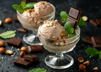 Chocolate Ice Cream with dark chocolate bars and hazelnuts in a glass bowl