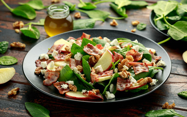 Bacon, Apple Salad with spinach, walnuts and feta cheese. on wooden table. healthy food.