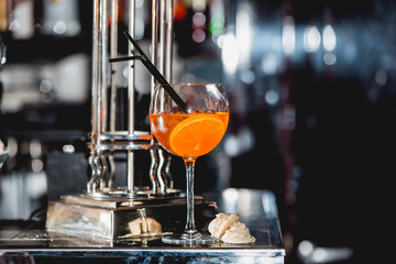 glass of refreshing orange alcoholic cocktail on a table in the bar