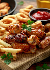 Fried Chicken wings with onion rings, french fries and dipping sauce. take away food.