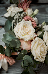 Natural wedding bouquet of white roses lies on an old beautiful chair