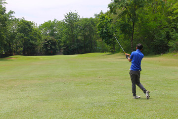 Golfer putting golf into the hole  in beautiful golf course. The evening golf course with sunset in thailand