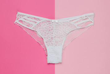 Women's sexy lace panties on a pastel pink background. Top view