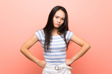 Teenager asian girl over isolated pink background angry