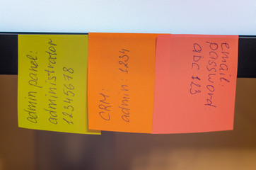 A very weak and widespread password is written on a sticker / stick note attached to a computer monitor. Password Security Weakness Concept. Typical information security failures. Bad password policy.
