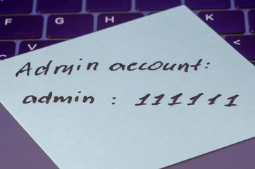 A very weak, simple and widespread password is written on a sticker that lies on the laptop...