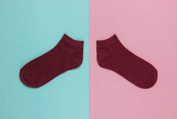Red socks on pink blue background. Pastel color trend. Top view