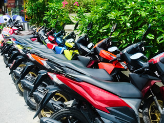 Popular motorbikes for tourists for rent. A row of colorful motorbikes for comfortable and fast travel on vacation in Asia