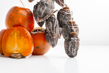 dried persimmon hanging on rope on white background