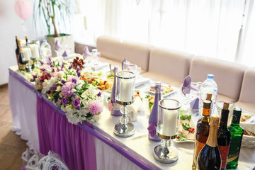 View of the served for decorated wedding dinner table in elite restaurant with beautiful flowers.