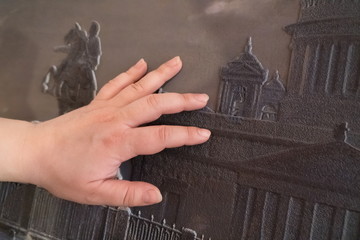 Female hand touches a special embossed pattern for the visually impaired.