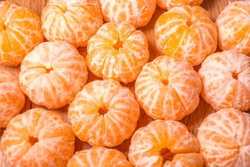 tangerines without peel on the table. background