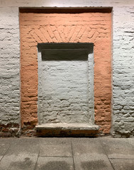bricked window in white and orange brick wall lighting from above in white and orange brick wall lighting from above