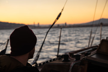Obraz premium Young man sailing alone with his sailboat.