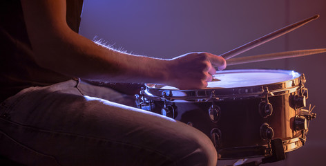 man playing the snare drum on a beautiful colored background