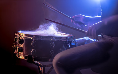 man playing the snare drum on a beautiful colored background