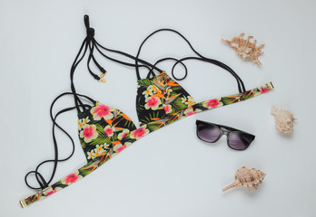Woman's swimsuit bikini and beach accessories on white background. Overhead view of woman's swimwear. Summer background, vacation on the beach. Flat lay, top view.