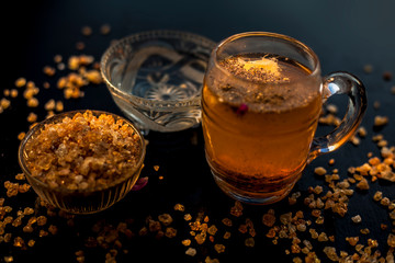 Special gond katria summer drink in a glass mug on wooden surface with some black pepper and lemon juice in it.Along with some spread gond, gum, edible gum crystals.