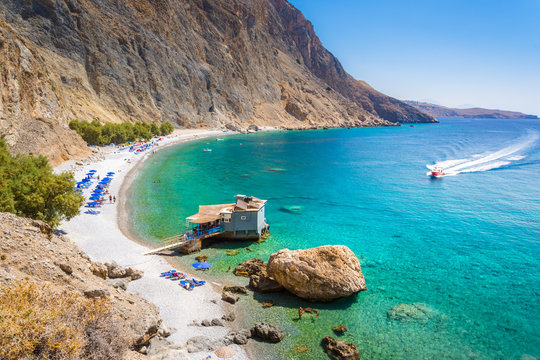 Glyka Nera beach (Sweet Water or Fresh Water). View of the remote and famous Sweet Water Beach in south Crete, with its unique tavern on the rock inside sea. This is a nudist beach.