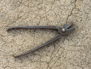 Obraz premium old metal scissors lying on cracked asphalt