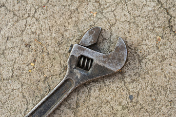 old adjustable spanner lying on pavement