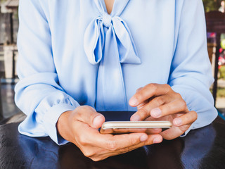 Business women hand used smartphone for online searching on black wooden table