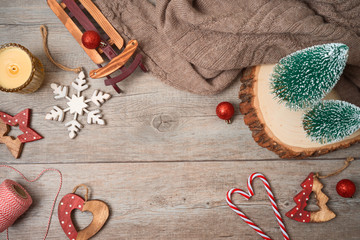 Christmas holiday hygge background with candle and decorations on wooden table.