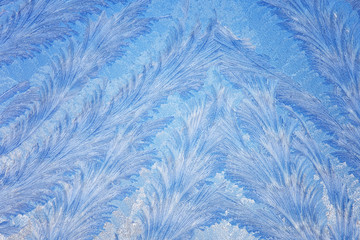 Frost forms in patterns on window glass on a cold winter morning
